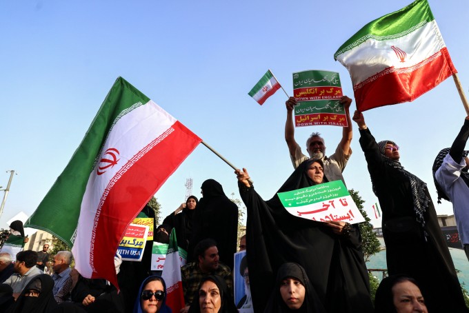 Người dân Iran vẫy cờ khi họ ăn mừng lệnh ngừng bắn giữa nước này với Israel tại Quảng trường Enghlab ở thủ đô Tehran ngày 24/6. Ảnh: AFP